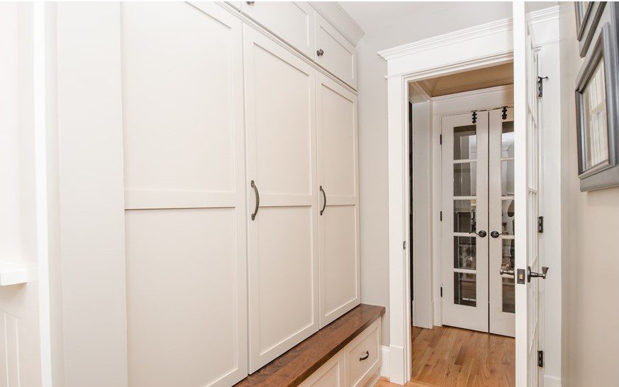 custom-designed mudroom in Dunwoody home with white cabinets for backpacks school supplies and sports equipment
