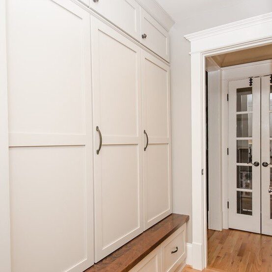 custom-designed mudroom in Dunwoody home with white cabinets for backpacks school supplies and sports equipment