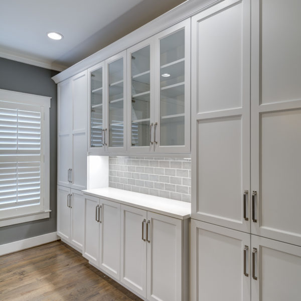 transitional kitchen design with white custom cabinets light grey subway tile large grey island luxury appliances and plantation shutters