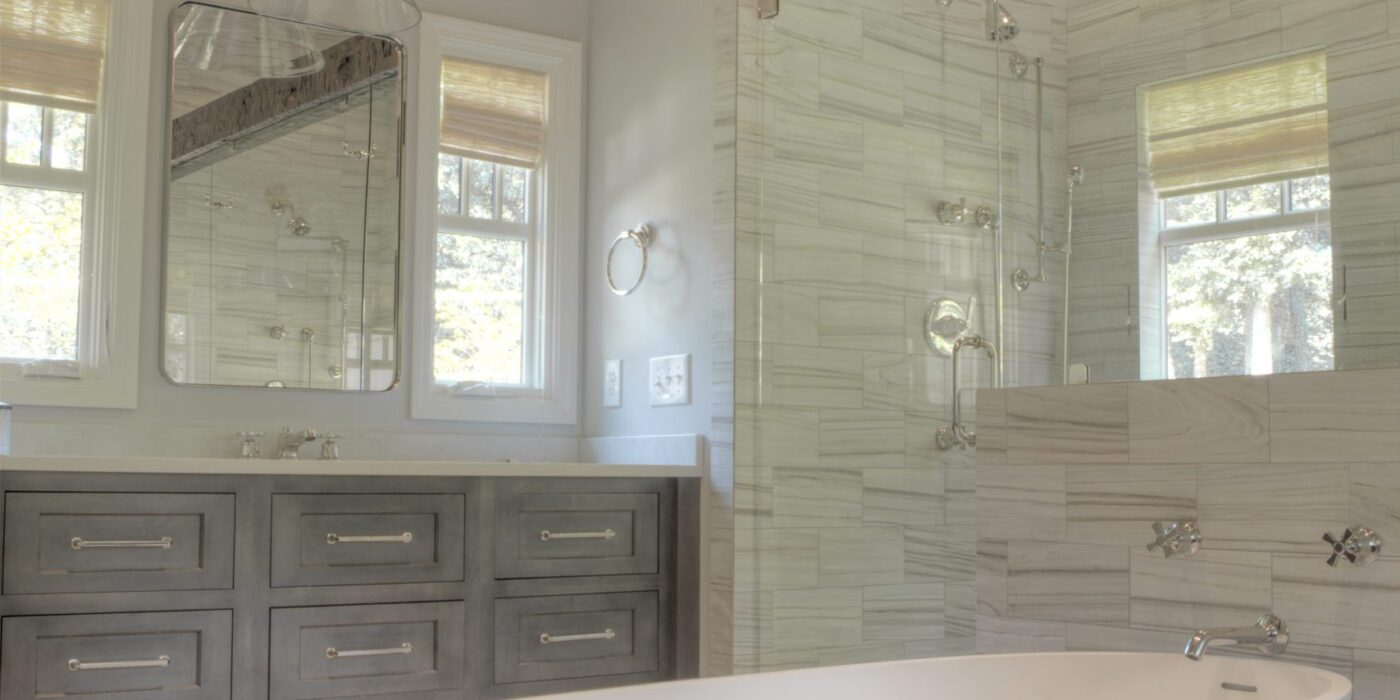 transitional bathroom renovation with large walk-in shower for two and large soaking tub with grey vanity and exposed beams