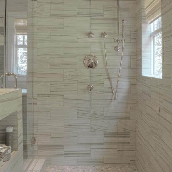 large walk-in shower with river rock flooring