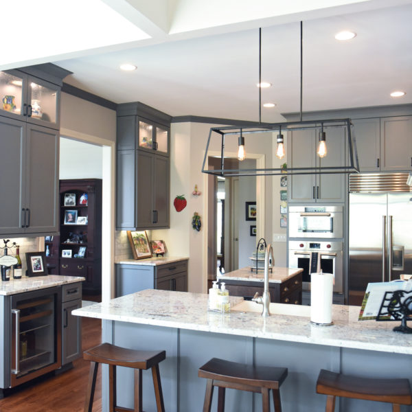 kitchen renovation with grey painted cabinets contrasting dark stained wood island luxury appliances
