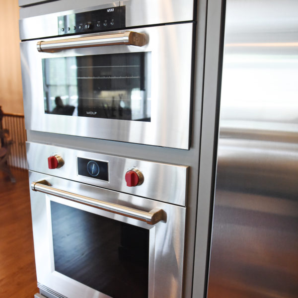 kitchen renovation with grey painted cabinets contrasting dark stained wood island luxury appliances