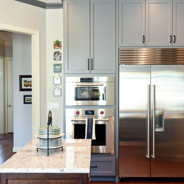 kitchen renovation with grey painted cabinets contrasting dark stained wood island luxury appliances