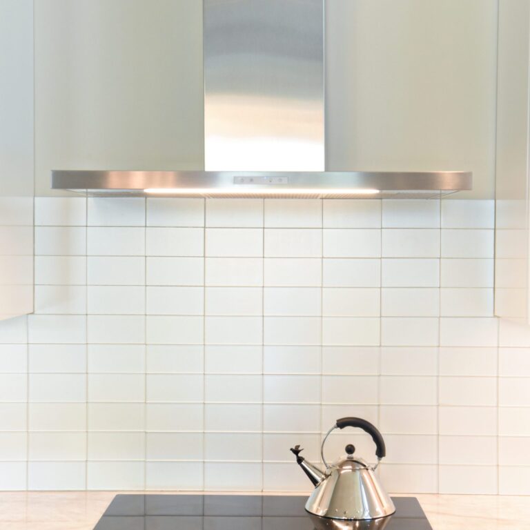 modern Atlanta white kitchen design featuring island with waterfall edge luxury appliances and contemporary pendant light fixtures