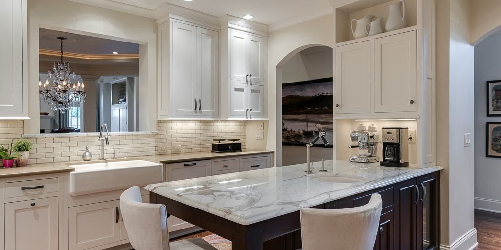 beautiful transitional kitchen with white cabinets and dark island with extra seating