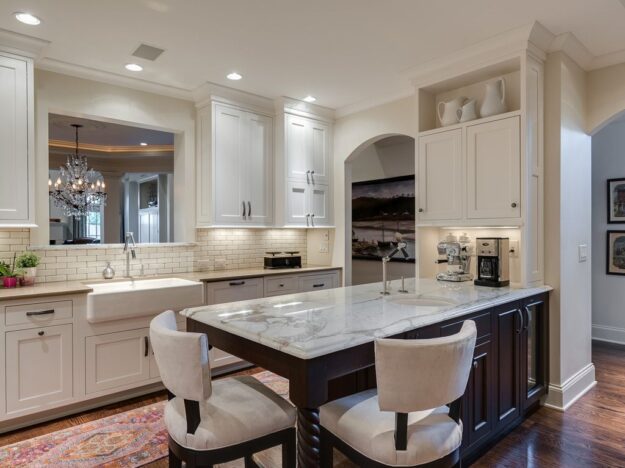 beautiful transitional kitchen with white cabinets and dark island with extra seating