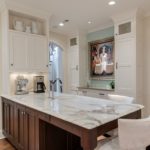 elegant transitional kitchen with white cabinets dark island with seating custom built-in storage cabinets