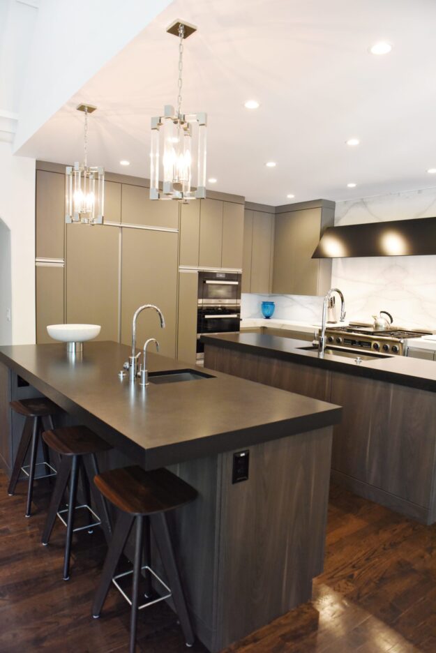 kitchen renovation with modern grey cabinets and dark wood cabinets featuring two islands and luxury appliances including two dishwashers
