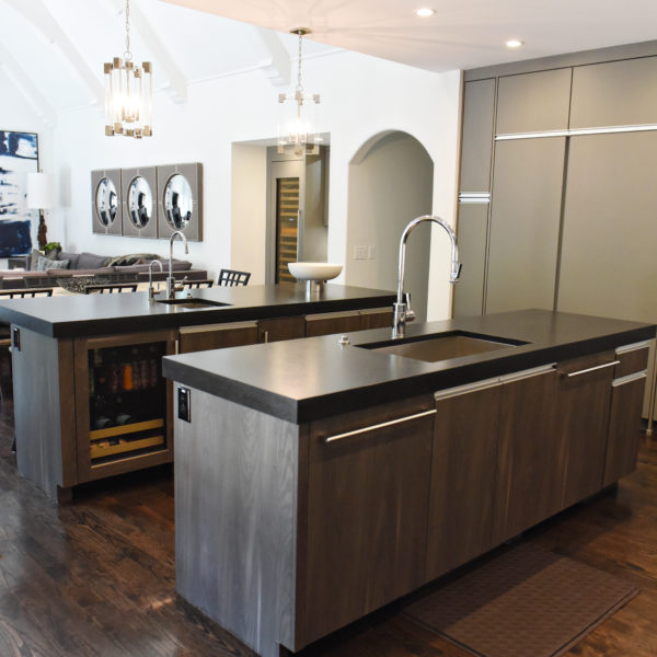 kitchen renovation with modern grey cabinets and dark wood cabinets featuring two islands and luxury appliances including two dishwashers