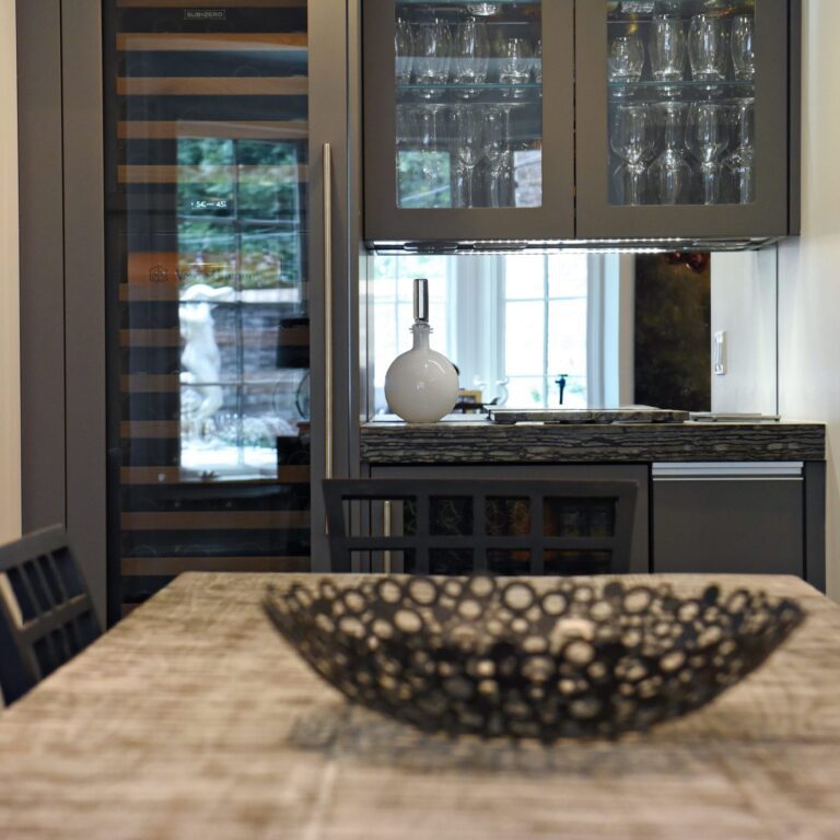 kitchen renovation with modern grey cabinets and dark wood cabinets featuring two islands and luxury appliances including two dishwashers