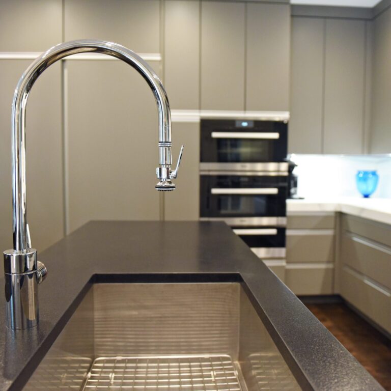 kitchen renovation with modern grey cabinets and dark wood cabinets featuring two islands and luxury appliances including two dishwashers