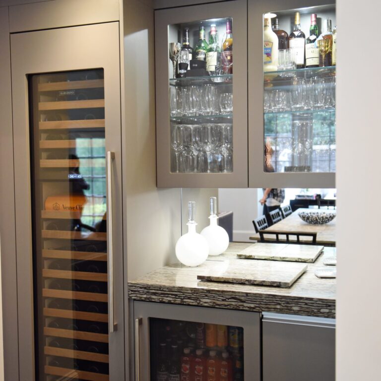 kitchen renovation with modern grey cabinets and dark wood cabinets featuring two islands and luxury appliances including two dishwashers