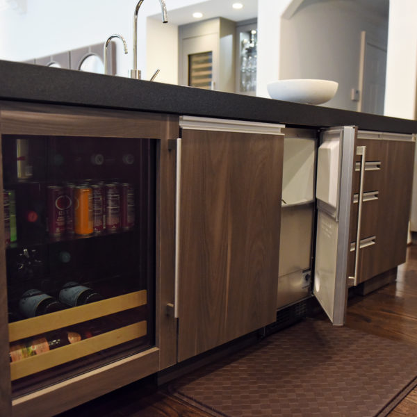 kitchen renovation with modern grey cabinets and dark wood cabinets featuring two islands and luxury appliances including two dishwashers