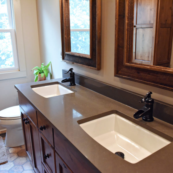 bathroom in a modern mountain cabin with double bowl vanity and two mirrors