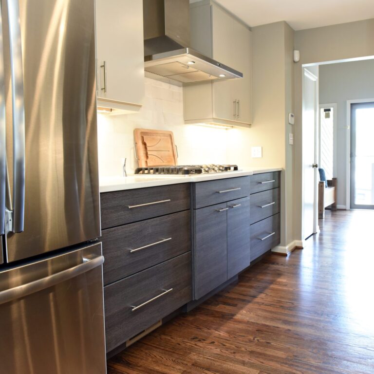 modern Atlanta kitchen design with dark contemporary lower cabinets and lighter upper cabinets with large island and luxury stainless steel appliances