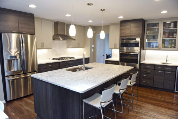 modern Atlanta kitchen design with dark contemporary lower cabinets and lighter upper cabinets with large island and luxury stainless steel appliances