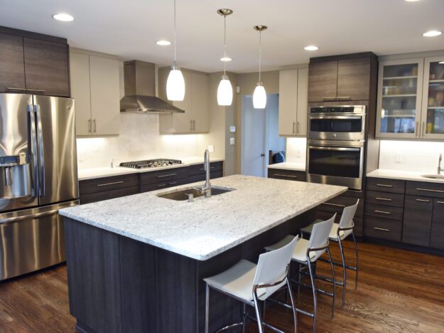 modern Atlanta kitchen design with dark contemporary lower cabinets and lighter upper cabinets with large island and luxury stainless steel appliances