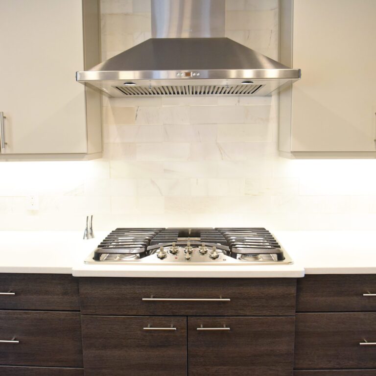 modern Atlanta kitchen design with dark contemporary lower cabinets and lighter upper cabinets with large island and luxury stainless steel appliances