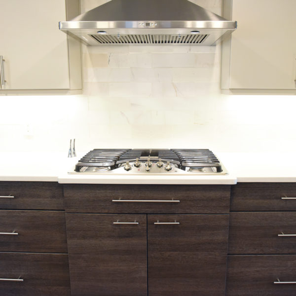 modern Atlanta kitchen design with dark contemporary lower cabinets and lighter upper cabinets with large island and luxury stainless steel appliances