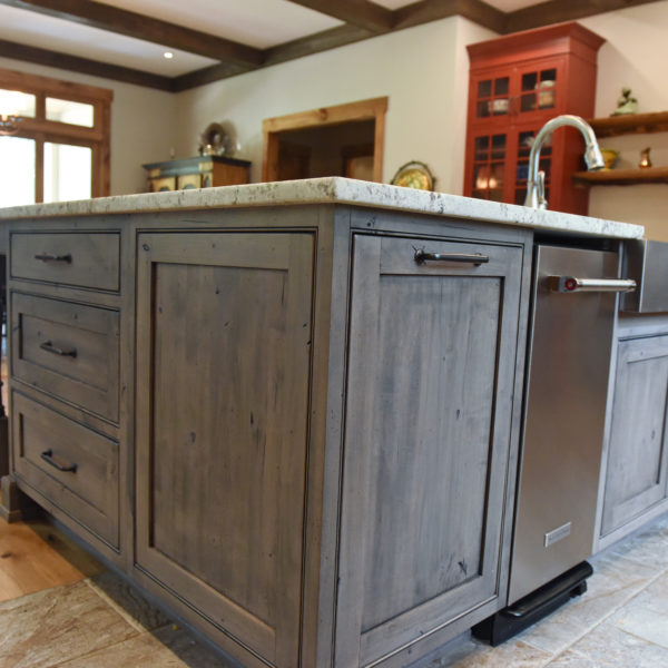 rustic kitchen renovation with custom grey cabinets large island with seating for four red pops of color on accent cabinets floating shelves exposed beams
