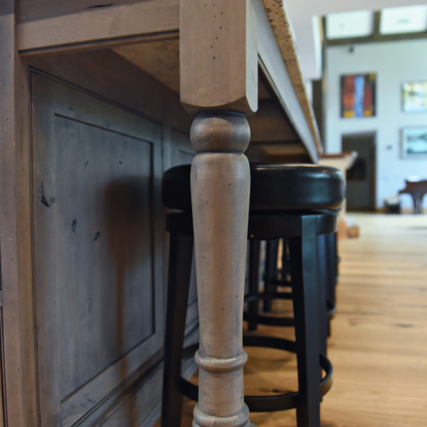 rustic kitchen renovation with custom grey cabinets large island with seating for four red pops of color on accent cabinets floating shelves exposed beams
