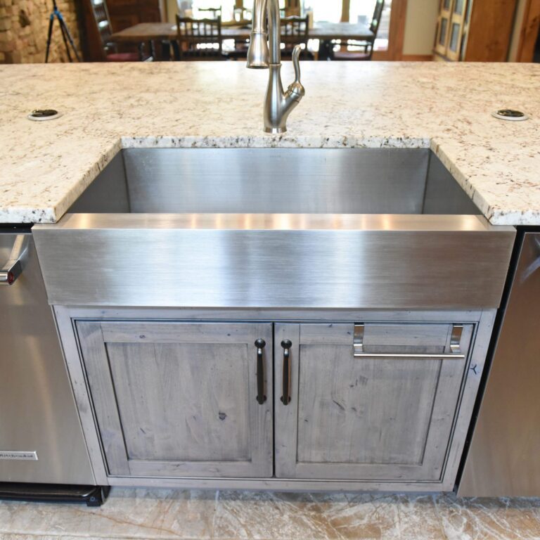 rustic kitchen renovation with custom grey cabinets large island with seating for four red pops of color on accent cabinets floating shelves exposed beams