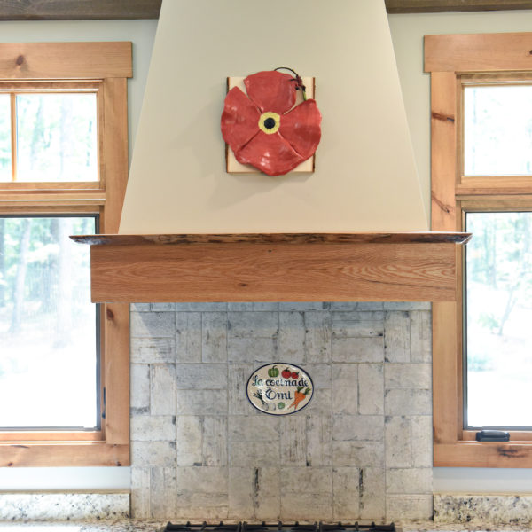 rustic kitchen renovation with custom grey cabinets large island with seating for four red pops of color on accent cabinets floating shelves exposed beams
