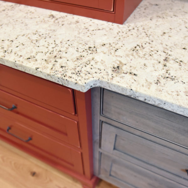 rustic kitchen renovation with custom grey cabinets large island with seating for four red pops of color on accent cabinets floating shelves exposed beams