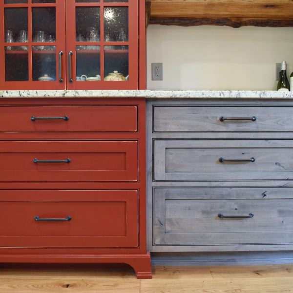 rustic kitchen renovation with custom grey cabinets large island with seating for four red pops of color on accent cabinets floating shelves exposed beams