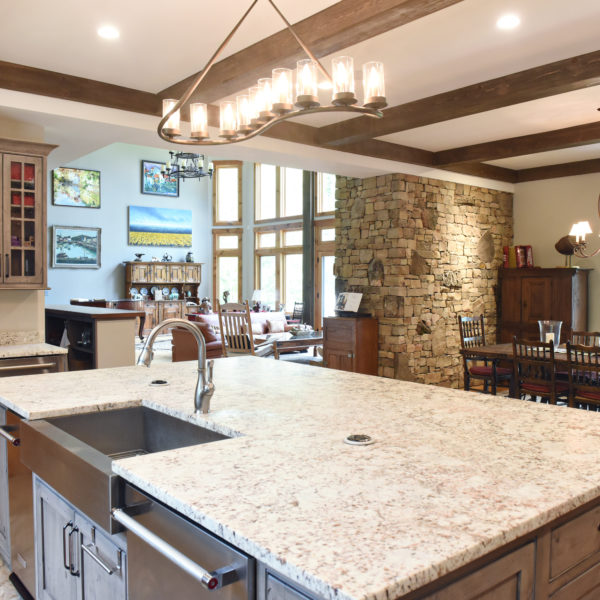 rustic kitchen renovation with custom grey cabinets large island with seating for four red pops of color on accent cabinets floating shelves exposed beams