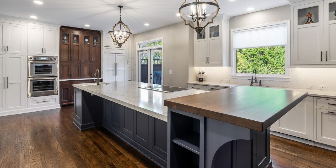 beautiful kitchen renovation in Roswell GA featuring large blue island with white upper and lower kitchen cabinets luxury appliances high-end light fixtures