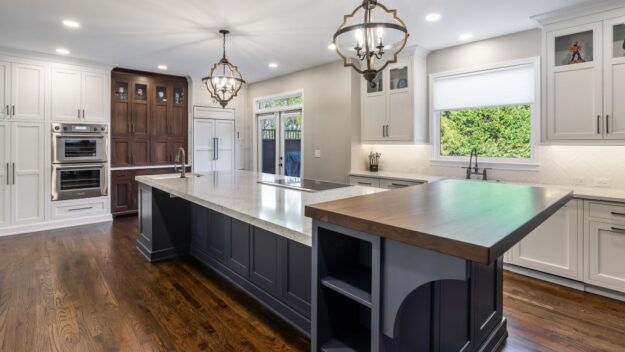 beautiful kitchen renovation in Roswell GA featuring large blue island with white upper and lower kitchen cabinets luxury appliances high-end light fixtures