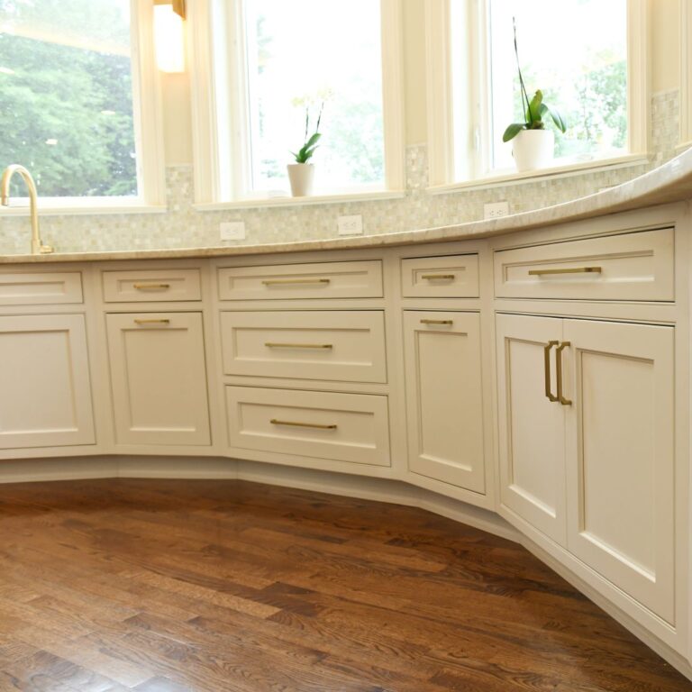 closed up of curved base cabinets in award-winning Atlanta kitchen features white custom curved base cabinets with elegant curved contrasting dark island