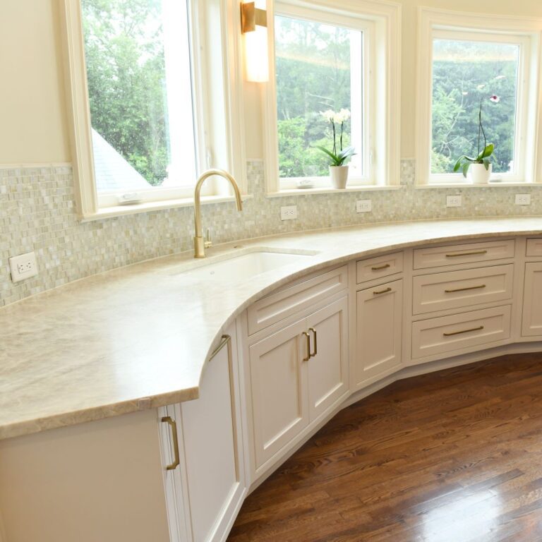 another close up of curved base cabinets in award-winning Atlanta kitchen features white custom curved base cabinets with elegant curved contrasting dark island