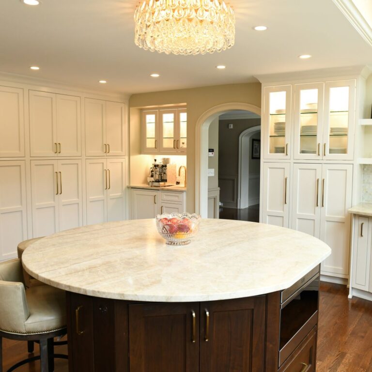 close up of island in award-winning Atlanta kitchen features white custom curved base cabinets with elegant curved contrasting dark island