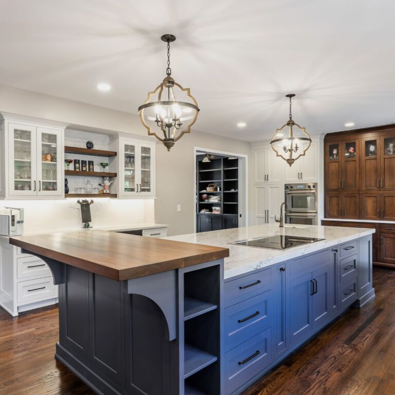 beautiful kitchen renovation in Roswell GA featuring large blue island with white upper and lower kitchen cabinets luxury appliances high-end light fixtures