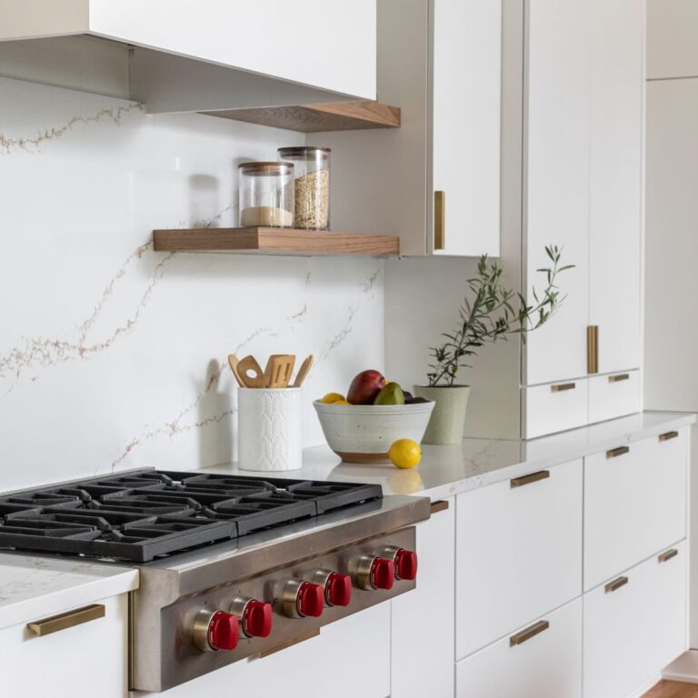 close up of luxury stove showing sleek cabinets and floating shelves in this contemporary kitchen renovation in Atlanta