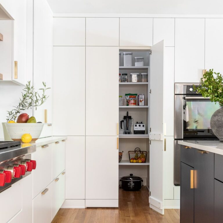 close up of open pantry cabinet in contemporary Atlanta kitchen renovation that features sleek white cabinets with gold hardware and lots of custom storage space