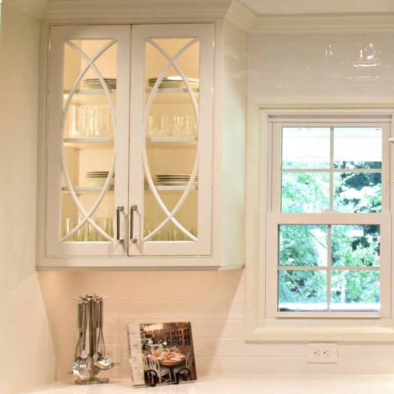 close up of a custom white kitchen cabinet with glass doors and arched inserts in an Atlanta kitchen redesign