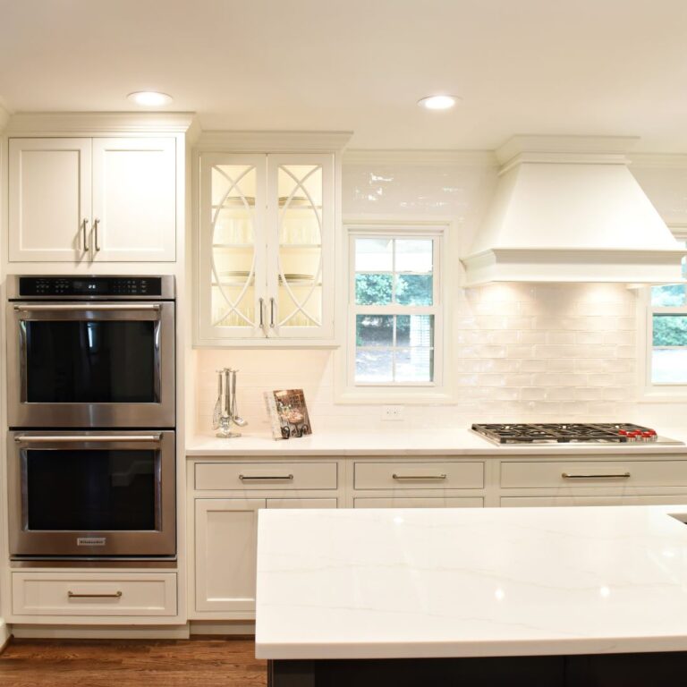 this Atlanta kitchen remodel features white subway tile, custom white cabinets, white marble countertops, double oven, counter cooktop and recessed lighting