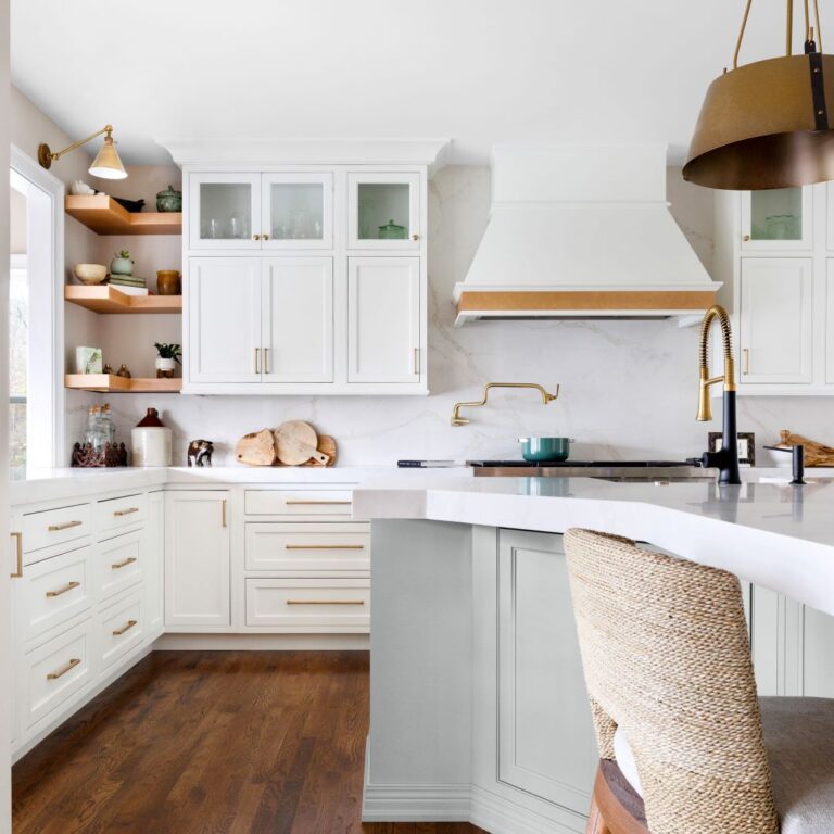 view of renovated kitchen in upscale Marietta, GA home featuring white custom cabinets and large white stove hood