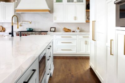 view of renovated kitchen in upscale home in Atlanta Country Club showing large island and beautiful white custom cabinets by Schuon Kitchens & Baths