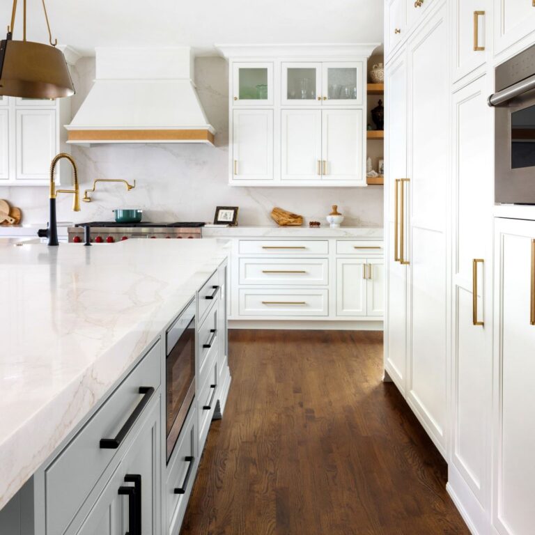 view of renovated kitchen in upscale home in Atlanta Country Club showing large island and beautiful white custom cabinets by Schuon Kitchens & Baths