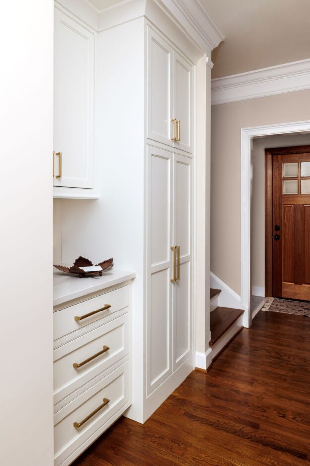 white custom cabinets in a hallway between a powder room and laundry area to provide extra storage in a beautiful home in Atlanta Country Club in Marietta Georgia