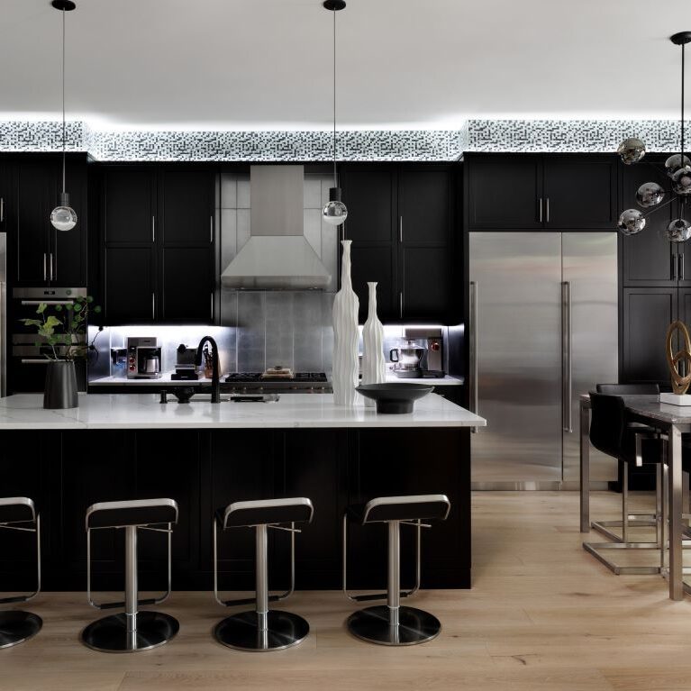 this pictures shows the soffit lighting accentuating the modern mosaic tile above the cabinets in this modern renovation