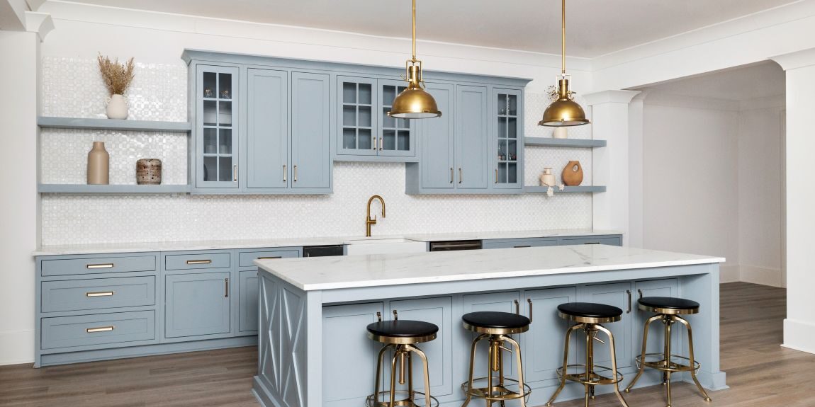this beautiful basement kitchenette in buckhead atlanta, GA features custom light blue cabinets, an island with seating for four, and gorgeous white counters