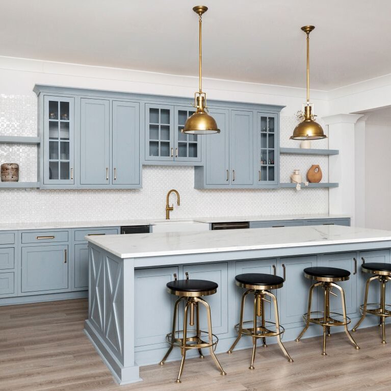 this beautiful basement kitchenette in buckhead atlanta, GA features custom light blue cabinets, an island with seating for four, and gorgeous white counters