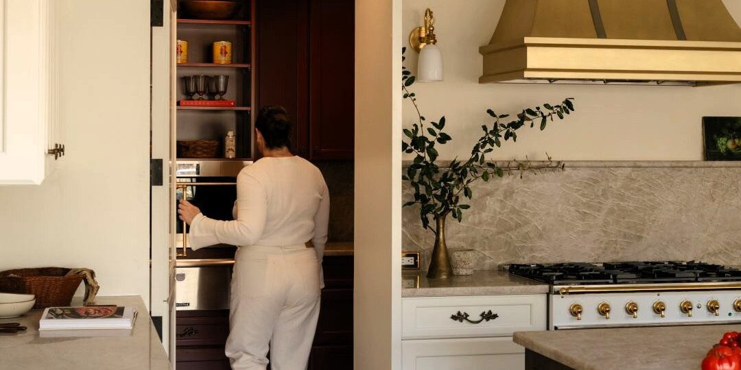picture of homeowner stepping into hidden pantry in luxury kitchen in Sandy Springs