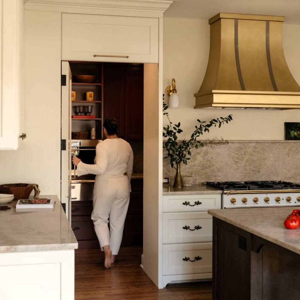picture of homeowner stepping into hidden pantry in luxury kitchen in Sandy Springs